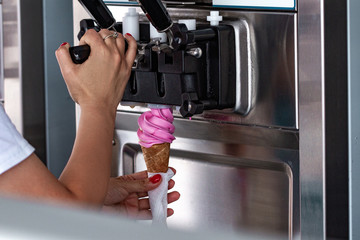 Preparation of fruit ice cream from ice cream machine during summer day