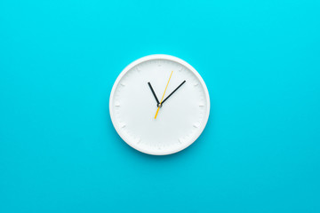 white wall clock with yellow second hand hanging on the wall. minimalist flat lay image of plastic w
