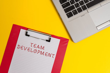 Conceptual hand writing showing Team Development. Concept meaning learn why and how small groups change over time with graphs Part view metallic laptop clipboard paper sheet colored background