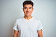 © Krakenimages.com - Young asian chinese man wearing t-shirt standing over isolated white background with a happy and cool smile on face. Lucky person.