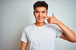 © Krakenimages.com - Young asian chinese man wearing t-shirt standing over isolated white background Pointing with hand finger to face and nose, smiling cheerful. Beauty concept