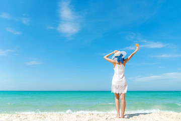 Summer Day. Lifestyle  woman wearing white dress fashion summer beach  on the sandy ocean beach. Happy woman enjoy and relax vacation and holiday. Travel Concept.