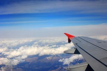 Airplane wing in the blue sky