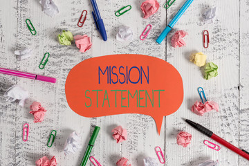 Handwriting text Mission Statement. Conceptual photo Formal summary of the aims and values of a company Blank speech bubble pens clips crushed paper balls vintage retro table