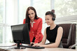 © spaskov - Two young women work in a bright office at the computer. Discuss workflows and enjoy a successful deal. Head and subordinate.