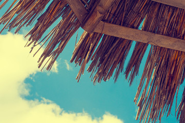 View from under the straw beach umbrella. Sun parasol. Blue clean sky and sunrise. Summer conception