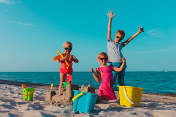 Poster - happy kids -boy and girls- play with sand on beach