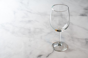 Empty wine glass on marble table top.