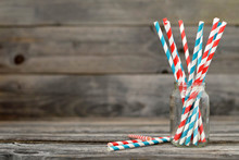 Paper straws in jar on wooden background with copy space