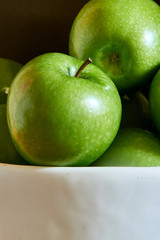 Wall Mural - Green Granny Smith cooking apples in a white bowl.