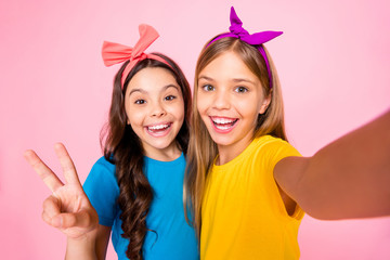 Close up photo of cheerful children make photo v-signs wear t-shirt headbands long wavy hairstyle trendy stylish isolated over pink background