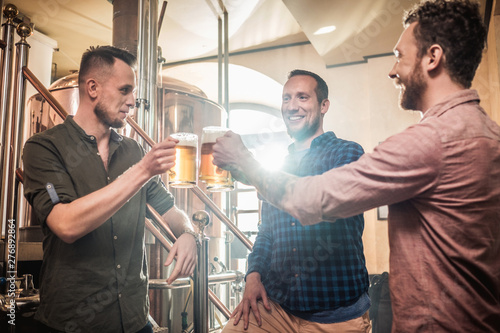 Three men tasting fresh beer in a brewery Poster Mural XXL