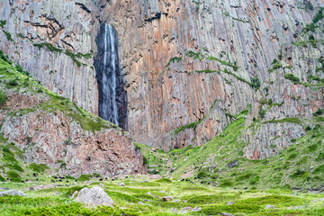 Summer landscape with mountain waterfall between two rocks