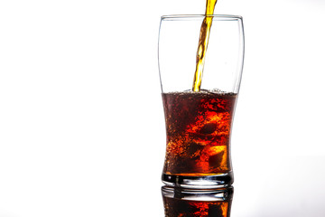 Wall Mural - pouring cola into glass with ice on white background Copy space