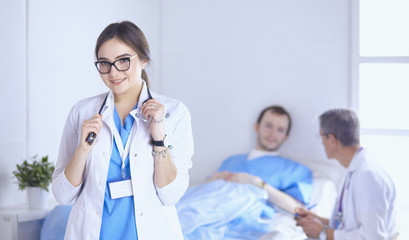 Wall Mural - Doctor checking heart beat of patient in bed with stethoscope