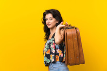 Young Woman Over Isolated Yellow Background Holding A Vintage Briefcase