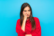 Young woman with red sweater over isolated blue background unhappy and frustrated
