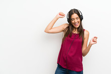 Young Woman Over Isolated White Background Listening To Music With Headphones