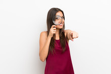 Young Woman Over Isolated White Background Holding A Magnifying Glass