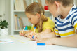 © spass - Cute schoolchildren are came back to school and learning at the table in classroom