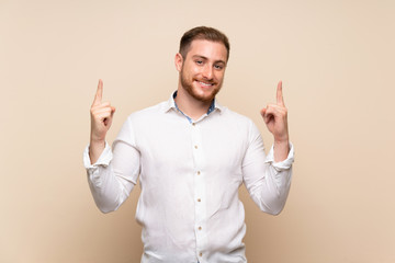 Blonde man over isolated background pointing up a great idea