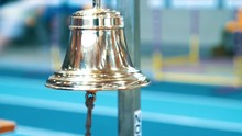 Referee ringing bell at finish of competition. Sports handbell closeup