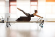© oscarfuentes - Pilates reformer workout exercises woman at gym indoor