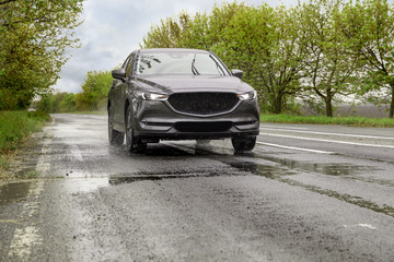 Wall Mural - Wet suburban road with car on rainy day