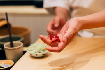 Japanese Omakase chef making Chutoro Sushi (Medium Fatty Bluefin Tuna) neatly by hands. Japanese traditional, authentic and luxury meal.