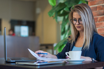 Business style. Beautiful girl working over a Cup of coffee