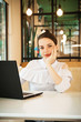 © Haibullaev - girl in cafe at lunch works behind a laptop