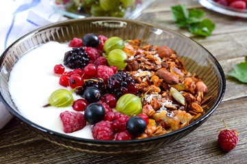 Wall Mural - Yogurt, granola, fresh berries in a bowl on a wooden table. Delicious and healthy breakfast. Proper nutrition. Dietary menu.