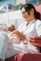 Wall Mural - Female doctor examining newborn baby after lunch. Night shift