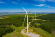 © whitcomberd - Aerial drone view of turbines at a large onshore windfarm on a green hillside (Pen y Cymoedd, Wales)