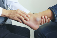 Closeup Of Man Feeling Pain In Her Foot And Doctor The Traumatologist Examines Or Treatment On White Background, Healthy Concept