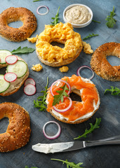 Wall Mural - Healthy Bagels breakfast sandwich with salmon, scrambled eggs, vegetables and cream cheese