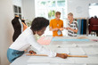 © zinkevych - Smiling pretty female tailor drawing a paper pattern