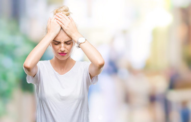 Wall Mural - Young beautiful blonde woman wearing white t-shirt over isolated background suffering from headache desperate and stressed because pain and migraine. Hands on head.