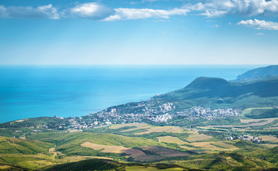 Wall Mural - Aerial scenic view of Alushta, Crimea, Russia. Resort city of Alushta from above in summer. Landscape of Crimea with seaside town. Panorama of the Black Sea coast. Scenery of Southern Crimea.