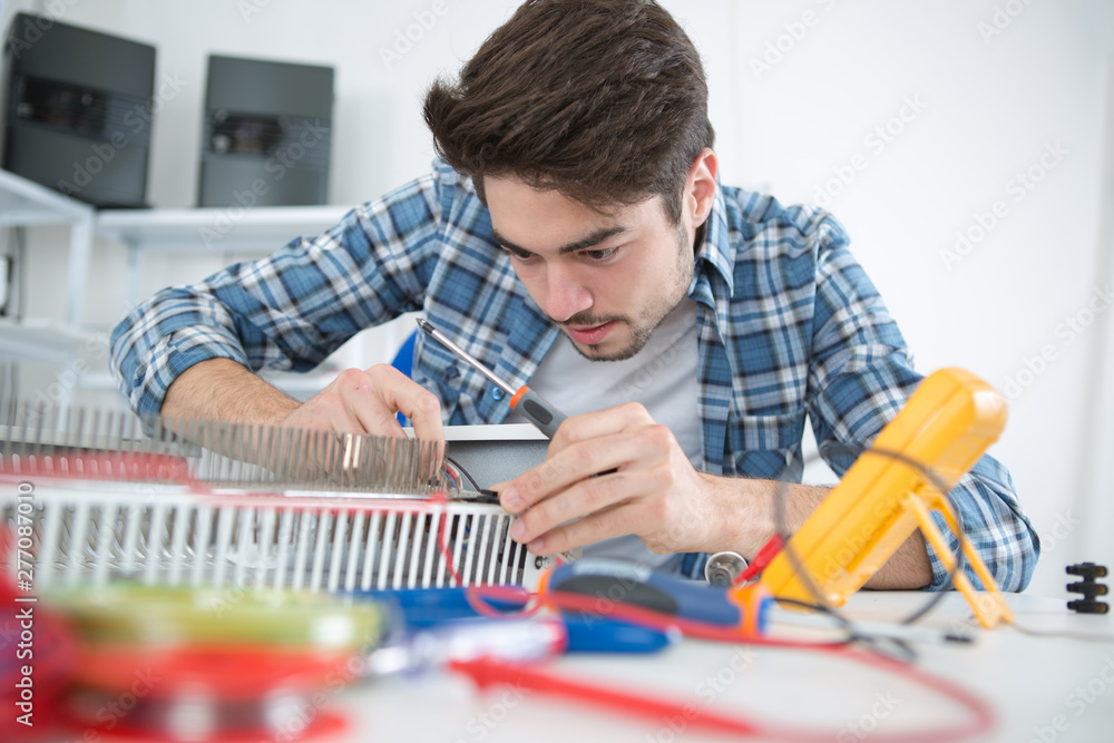 young electrical appliance assembler at work - obrazy, fototapety, plakaty 