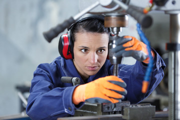 professional serious woman working with an electric drill