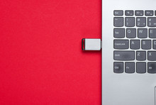 Laptop With Flash Drive On A Red Background. Top View