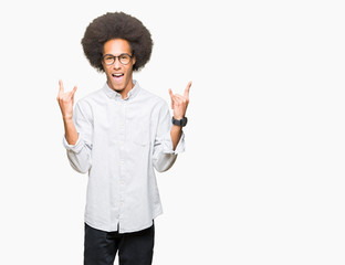 Young african american man with afro hair wearing glasses shouting with crazy expression doing rock symbol with hands up. Music star. Heavy concept.