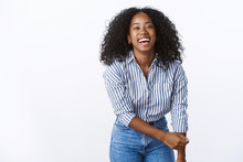 Wellbeing Happiness People Concept. Entertained Charming Friendly Carefree African American Woman Curly-haired Bending Towards Camera Having Fun Playful Mood Smiling Broadly Happy, Laughing