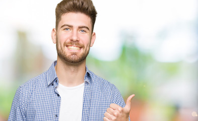 Young handsome blond man wearing casual shirt doing happy thumbs up gesture with hand. Approving expression looking at the camera with showing success.