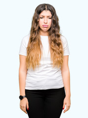 Canvas Print - Young beautiful woman wearing casual white t-shirt depressed and worry for distress, crying angry and afraid. Sad expression.