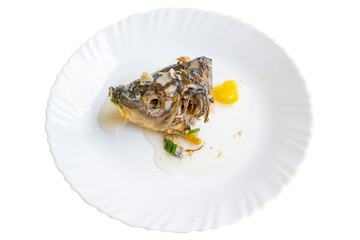 Head of cooked fish on white plate