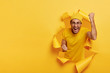 © WHstudio Leushin N - Joyous cheering guy clenches fists with triumph, happy win game, has successful day, wears yellow outfit, stands inside of torn paper hole, free space on left for your text information. Nice work