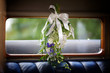 wedding flowers hanging in a car with white ribbon