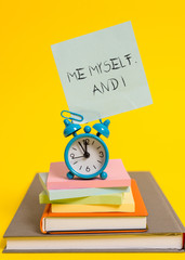 Handwriting text writing Me Myself And I. Conceptual photo used by speaker to refer to herself as the object of a verb Alarm clock note stacked notepads old books colored background